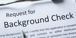 Image of a background check request form on a clip board, being filled out